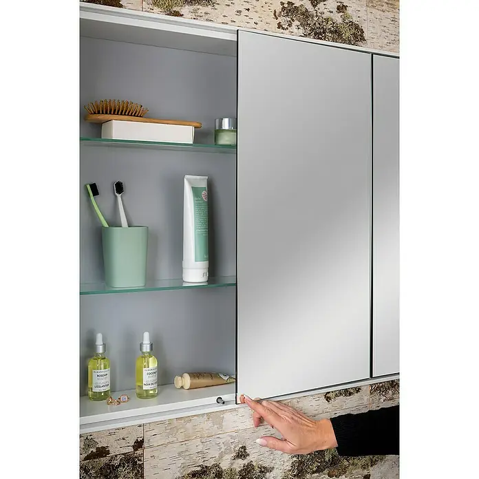 Lanzet Dune LED-Spiegelschrank - B x H: 101,8 x 70,2 cm, Holz, Schwarz - Ein Badezimmerschrank mit Spiegeltüren, der Pflegeprodukte wie Lotionen, Zahnbürsten und eine Haarbürste enthält.