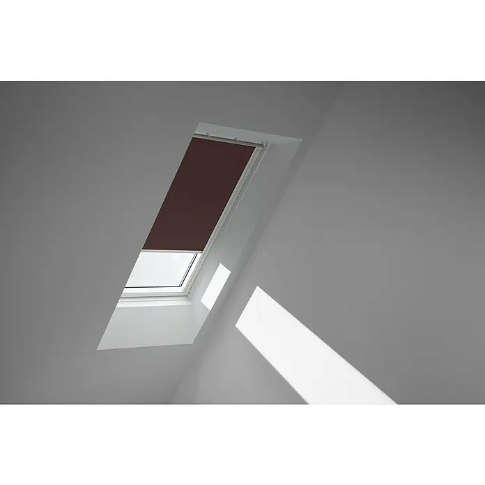 Velux Dachfensterrollo DKL PK08 4559SWL - Farbe: Rehbraun - 4559SWL, Farbe Schiene: Weiß, Manuell - Dachfenster mit braunem Rollo, das einen Teil des Fensters bedeckt und einen Lichtstrahl auf die weiße Wand wirft.