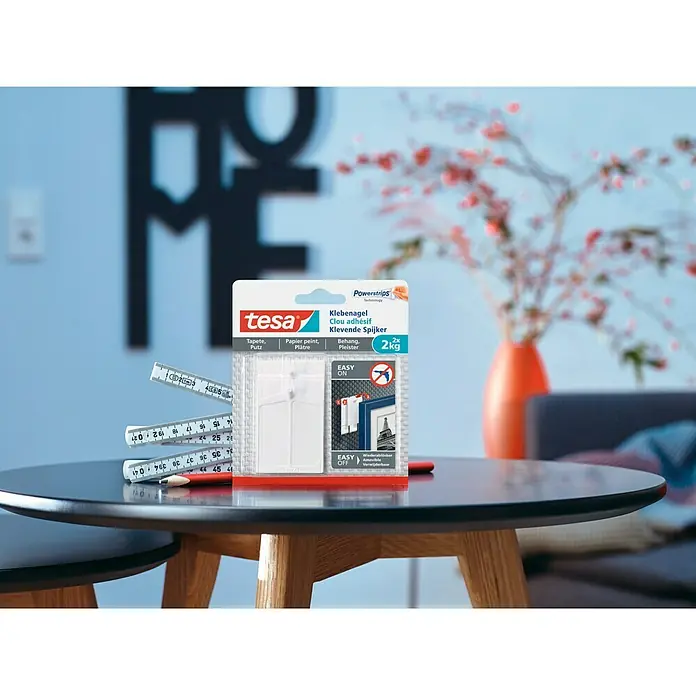 Tesa Clavo adhesivo - Blanco, Carga soportada: 2 kg, 2 ud., Paredes pintadas - Primer plano de los clavos adhesivos Tesa, ideales para colgar objetos sin perforar. Solución práctica para una sencilla decoración mural.