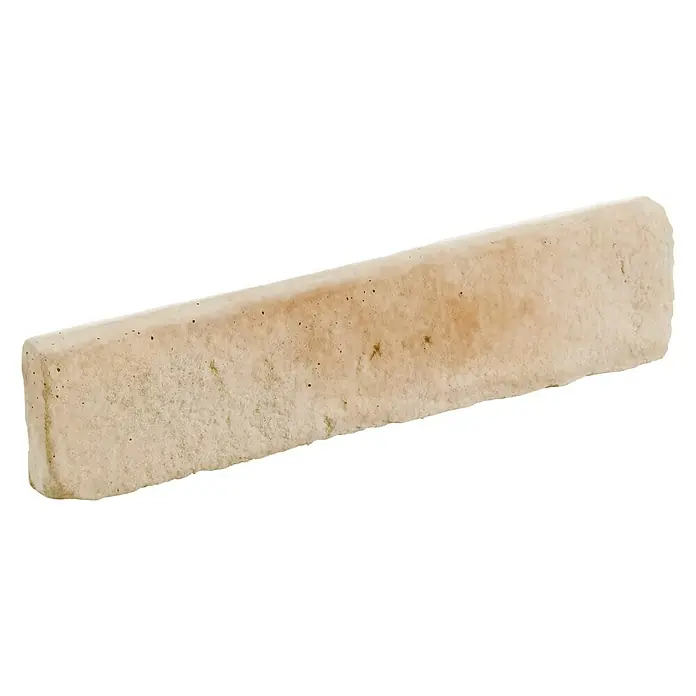 Revestimiento de piedra Mediterráneo Nácar - 24 x 5,5 x 2,5 cm - Primer plano de un ladrillo rectangular alargado con una superficie irregular en un cálido tono beige.