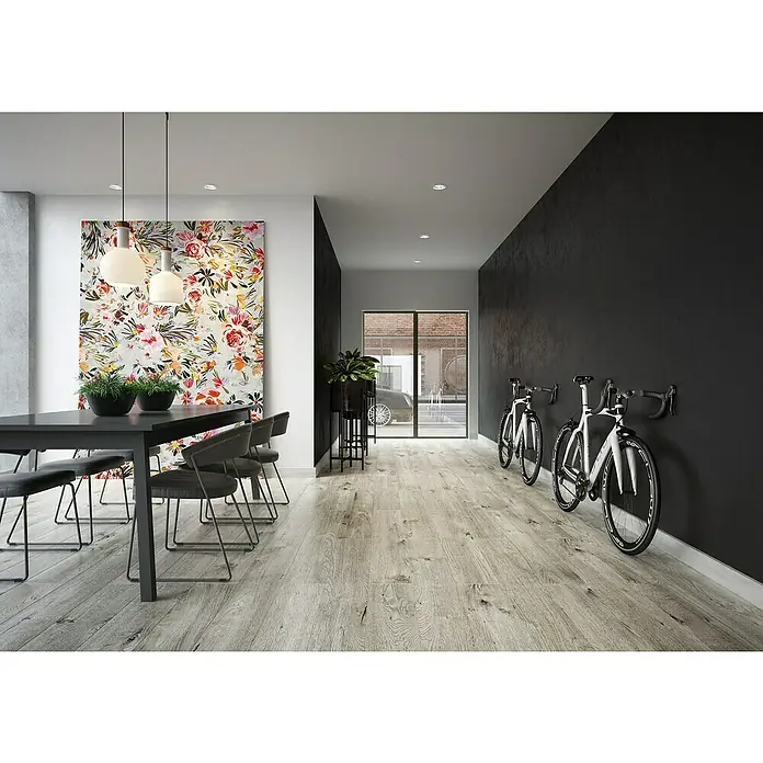 LOGOCLIC Rodapié Roble Ferik - 220 cm x 15 mm x 80 mm, MDF - Interior elegante con una mesa de comedor estilosa y bicicletas blancas contra una pared oscura. La iluminación moderna y la obra de arte complementan el diseño.