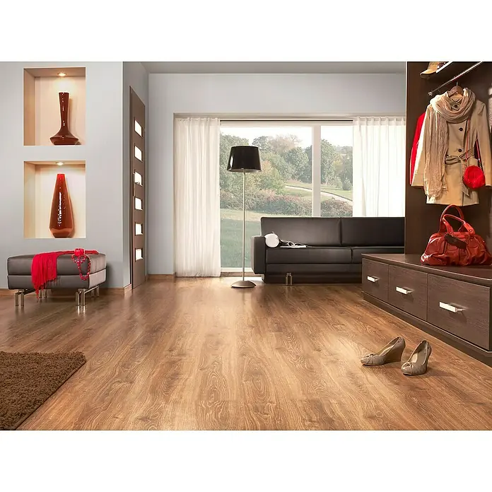 LOGOCLIC Junta de transición Selva/Energy - 2,44 m x 42 mm x 16 mm, Pegado - Amplia sala de estar con suelo de madera, un sofá marrón, un armario a juego y cortinas claras frente a una gran ventana.