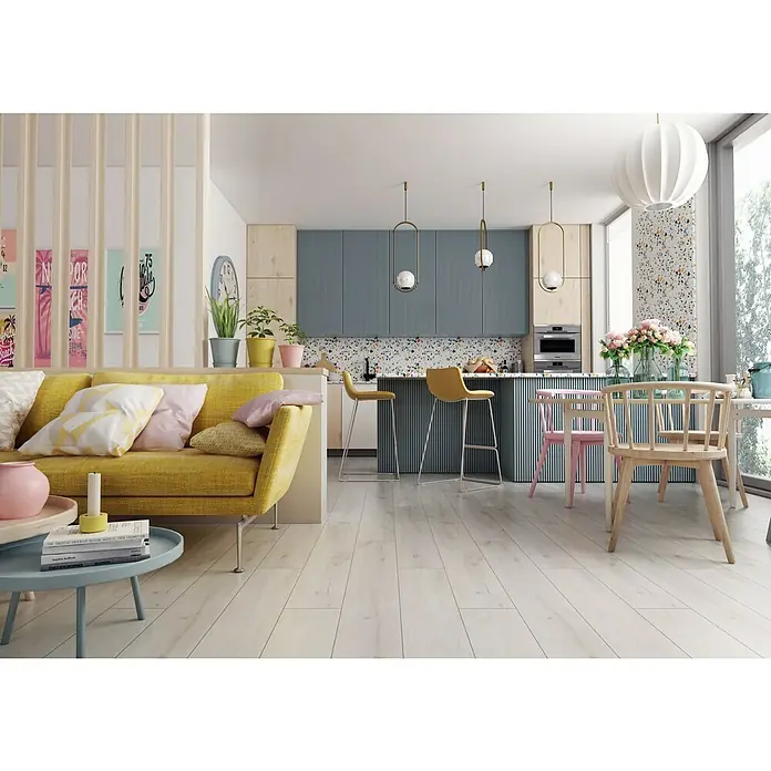 LOGOCLIC Laminado Roble Rimini - 1.375 x 188 x 12 mm, AC5 - Salón moderno y luminoso con sofá amarillo, cocina elegante y suelo de madera. La decoración combina confort y diseño de manera elegante.