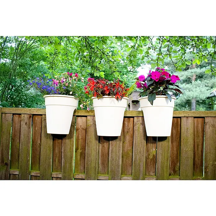 KHW Geländertopf Flowerclip - Außenmaß (Ø x H): 27 x 27,5 cm, Kunststoff, Weiß - Drei weiße Blumentöpfe mit farbenfrohen Blumen hängen an einem Holzzaun vor einer grünen Kulisse. Die Töpfe sind der Blickfang.