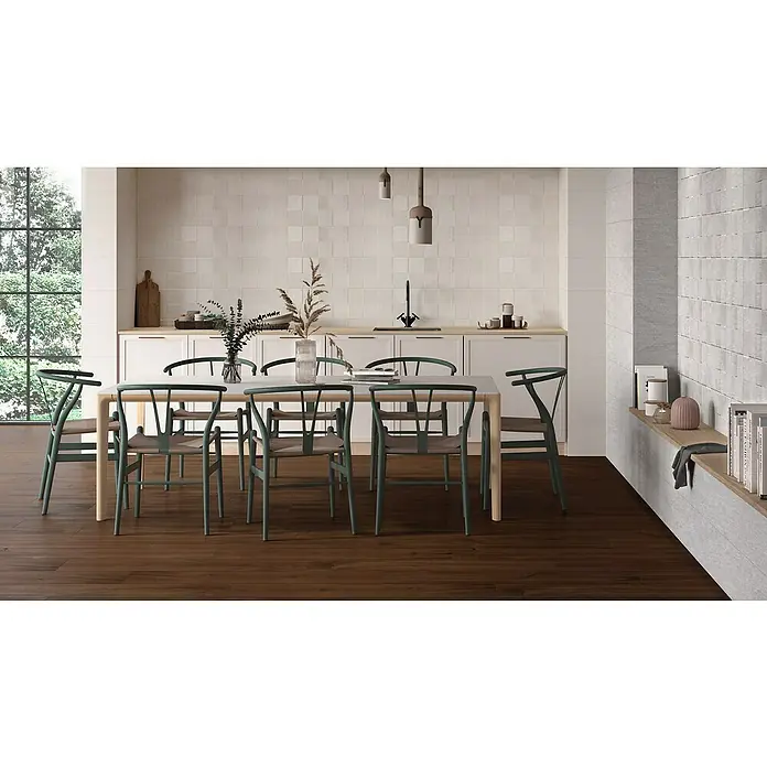 BHS Showroom Pavimento porcelánico Selva - 119,5 x 22,5 cm, Wengué, Mate, Rectificado - Vista acogedora del comedor con una gran mesa de madera rodeada de sillas verdes y elegantes lámparas colgantes sobre la mesa.