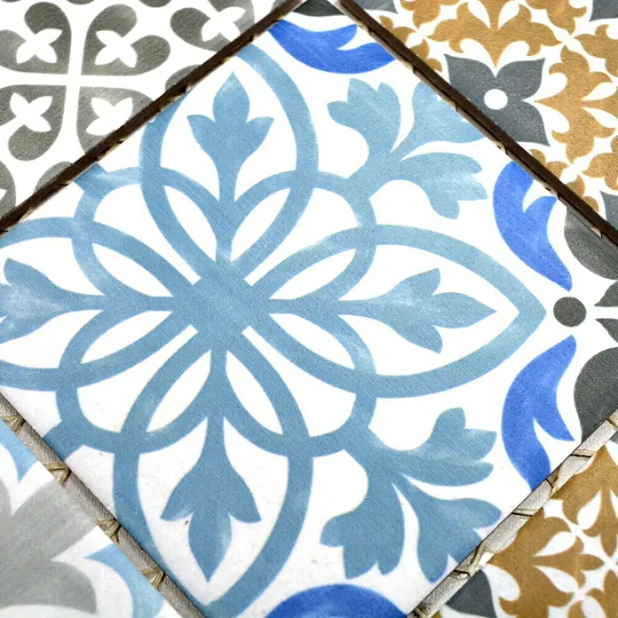 Mosaikfliese Quadrat Classico Mix Porto - 29,8 x 29,8 cm, Mehrfarbig, Matt - Nahaufnahme eines blauen, weiß gemusterten Keramikfliesenmosaiks, das ein dekoratives florales Muster zeigt.