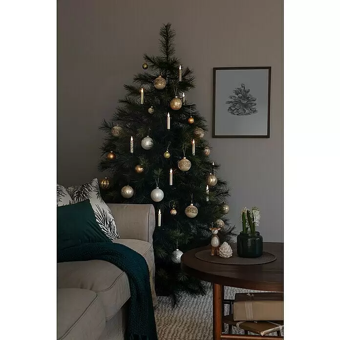 Konstsmide LED-Weihnachtskerzen - 1,8 cm, Weiß, Lichtfarbe: Warmweiß, 10 Stk., IP20 - Ein festlicher Weihnachtsbaum mit gold- und silberfarbenen Kugeln und leuchtenden Kerzenlichtern in einem gemütlichen Wohnzimmer.