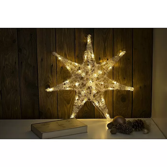 Konstsmide LED-Stern - 45 cm, Farblos, Lichtfarbe: Warmweiß, IP20, Netzbetrieben - Sternförmige LED-Leuchtdekoration aus klarem Material, die ein warmes Licht vor einer Holzwand abgibt, als festlicher Akzent.