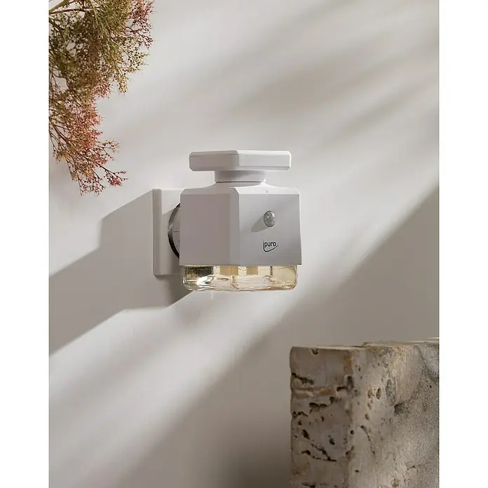 Ipuro Essentials Raumduft Duftstecker Scent Plug-In - 1 Stk., Weiß - Nahaufnahme eines iPurus Duftsteckers an einer weißen Wand, der für eine angenehme Raumatmosphäre sorgt.