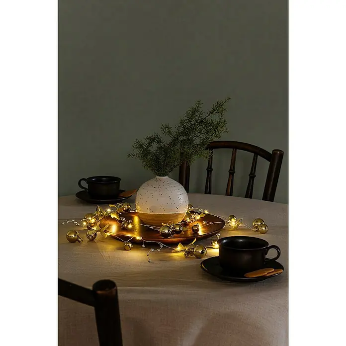 Konstsmide LED-Lichterkette - Innen, Lichtfarbe: Warmweiß, Anzahl Leuchtmittel: 20 Stk., Batteriebetrieben - Festlicher Tisch mit Kugeln, Lichtern und Vase.