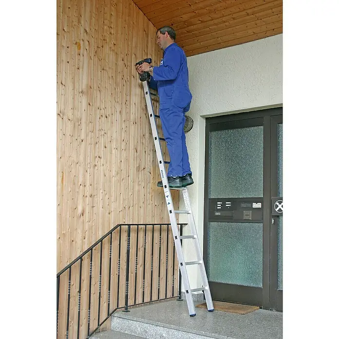 Krause Stabilo Anlegeleiter - Anzahl Tritte: 9 Stk., Arbeitshöhe: 3,6 m, Aluminium - Mann benutzt eine Krause Leiter vor einer Holzwand.