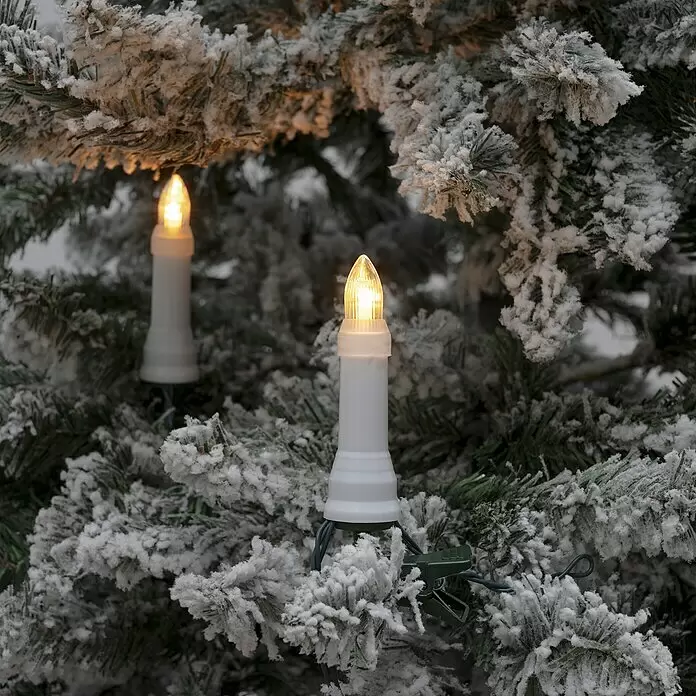 Konstsmide LED-Weihnachtskerzen - 21,8 mm, Weiß, Lichtfarbe: Bernstein, 25 Stk., IP44 - Zwei weiße LED-Kerzenlichter mit warmem Glanz an einem gefrosteten künstlichen Weihnachtsbaum.