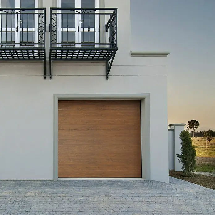 Solid Elements Garagentor Solid Pro - B x H: 2.500 x 2.125 mm, Golden Oak/Weiß - Eine moderne Garage mit einem Holztor und einem schmiedeeisernen Balkon darüber, die ein elegantes und funktionales Designelement darstellt.