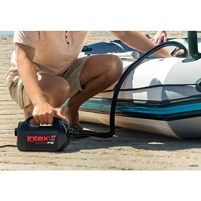 Intex Luftpumpe Quick Fill - 110 W - Schwarze Intex QuickFill Elektropumpe bläst ein Schlauchboot auf, gehalten von einer Person.