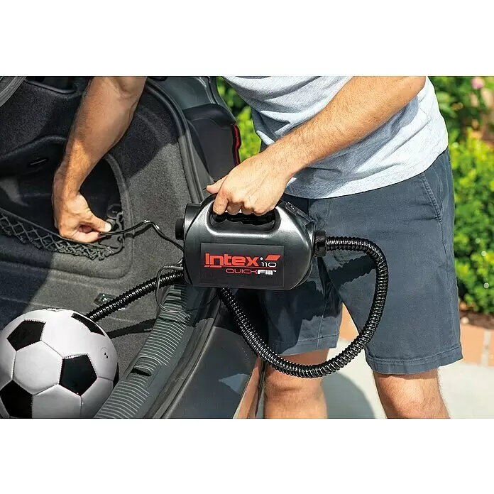 Intex Luftpumpe Quick Fill - 110 W - Person hält schwarze Intex QuickFill Elektropumpe mit Schlauch nahe Kofferraum, neben einem Fußball.