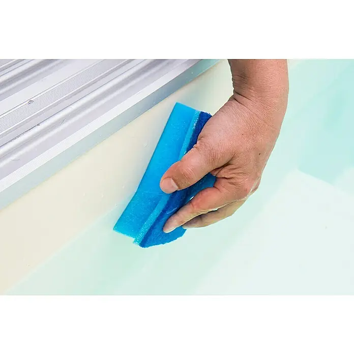Steinbach Handschrubber - 2 Stk. - Ein blaues Reinigungspad wird von einer Hand gehalten und zum Reinigen der Oberfläche eines Swimmingpools oder einer Badewanne verwendet.