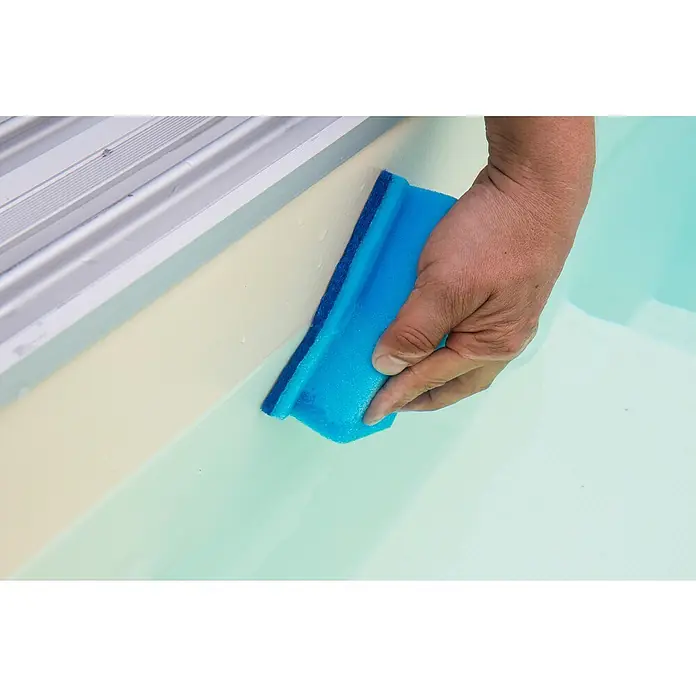 Steinbach Handschrubber - 2 Stk. - Eine Hand reinigt mit einem blauen Schwamm den Rand eines Pools, um ihn sauber zu halten und Algenbildung vorzubeugen.