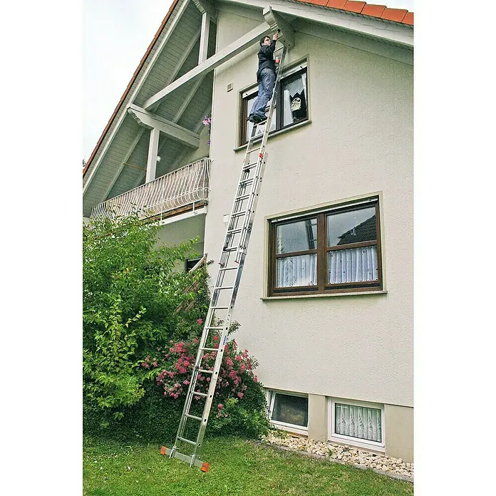 Krause Monto Seilzugleiter Robilo - Anzahl Tritte: 30 Stk., Arbeitshöhe: 8,45 m, Aluminium - Mann auf einer KRAUSE Leiter, der ein Haus streicht. Die vielseitige KRAUSE Leiter bietet sicheren Stand für Arbeiten in der Höhe.