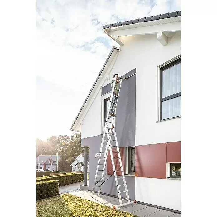 Krause Monto Mehrzweckleiter Tribilo - Arbeitshöhe: 9,3 m, Anzahl Tritte: 36 Stk., Belastbarkeit: 150 kg, Aluminium - Mann auf Aluminiumleiter vermisst die Fassade eines modernen Hauses.