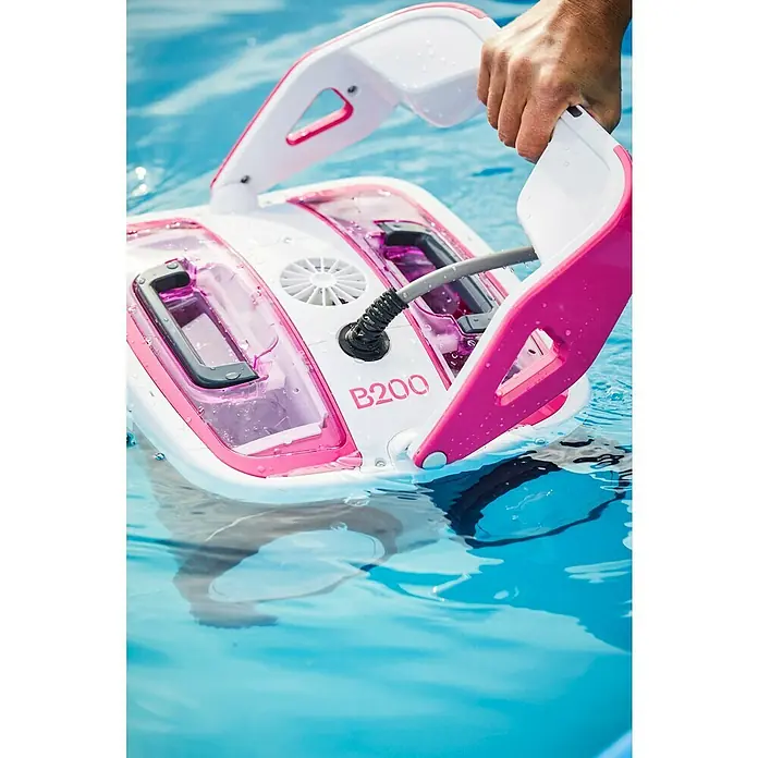 BWT Poolroboter B 200 - Netzbetrieben, Passend für: Pools bis 60 m² - Ein Poolreinigungsroboter B200 mit pinkfarbenen Akzenten wird von einer Person in ein Schwimmbecken gehalten.