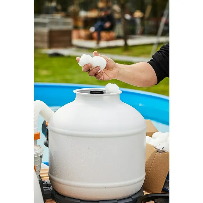 Malibu Filterbälle - 0,7 kg - Nahaufnahme eines Poolfilters, der mit Filterbällen befüllt wird, um eine effiziente Reinigung zu gewährleisten.