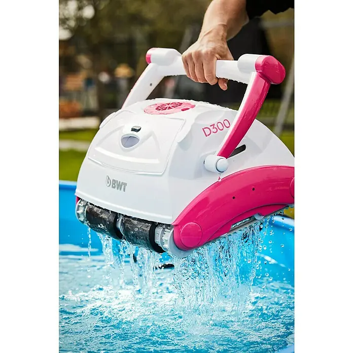 BWT Poolroboter D 300 - Netzbetrieben, Passend für: Pools bis 100 m² - Der BWT D300 Poolreinigungsroboter wird über einem Pool gehalten, Wasser tropft von den Bürsten. Der Roboter ist weiß mit pinkfarbenen Akzenten.