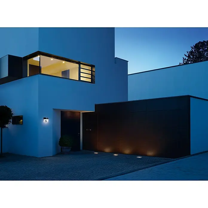 Steinel XSolar Solar-Hausnummer LH-N anthrazit - IP44, Anthrazit - Modernes Haus mit Außenbeleuchtung am Abend. Die Außenleuchten sind in die Pflastersteine eingebaut und beleuchten die Garagenwand.