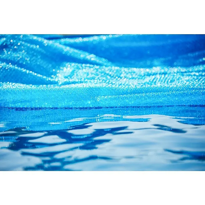 Malibu Solarabdeckplane - Durchmesser: 460 cm, 180 µm - Nahaufnahme einer blauen Poolabdeckung, die auf dem glitzernden Wasser eines Schwimmbades liegt und die Wärme speichert.