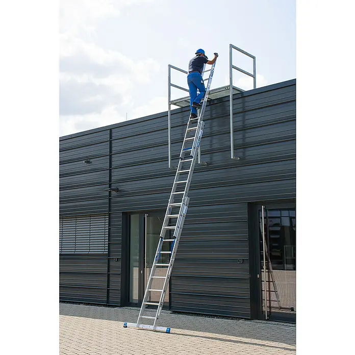 Krause Stabilo Mehrzweckleiter +S - Anzahl Tritte: 30 Stk., Arbeitshöhe: 7,5 m, Aluminium - Mann steigt auf eine Leiter, die an einem Gebäude mit einer Plattform befestigt ist.