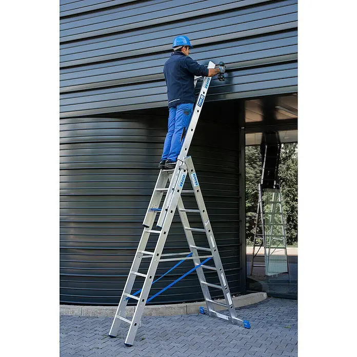 Krause Stabilo Mehrzweckleiter +S - Anzahl Tritte: 24 Stk., Arbeitshöhe: 5,95 m, Aluminium - Ein Mann auf einer Krause Leiter bei der Arbeit an einer Fassade. Die Leiter ist vielseitig und robust.
