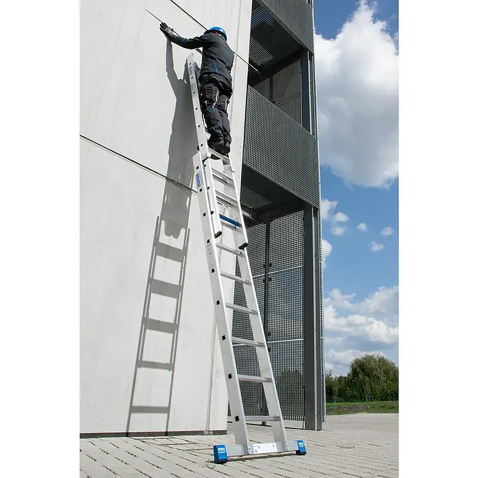 Krause Stabilo Schiebeleiter +S - Anzahl Tritte: 18 Stk., Arbeitshöhe: 5,15 m, Aluminium - Ein Mann auf einer KRAUSE Leiter vor einem Gebäude, der eine Reparatur durchführt. Sicher und zuverlässig für Arbeiten in der Höhe.