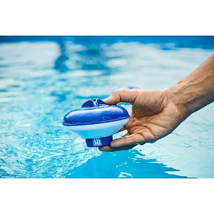 Malibu Schwimmdosierer - Geeignet für: Tabs - Hand hält einen blau-weißen schwimmenden Pool-Chemikalienspender, teilweise im klaren blauen Wasser.