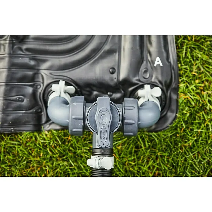 Intex Solarmatte - 120 x 120 cm, 1.250 l/h - Nahaufnahme einer Intex Poolheizmatte mit Anschlüssen und Ventil auf Rasen. Die Heizmatte ist schwarz und das Ventil grau.