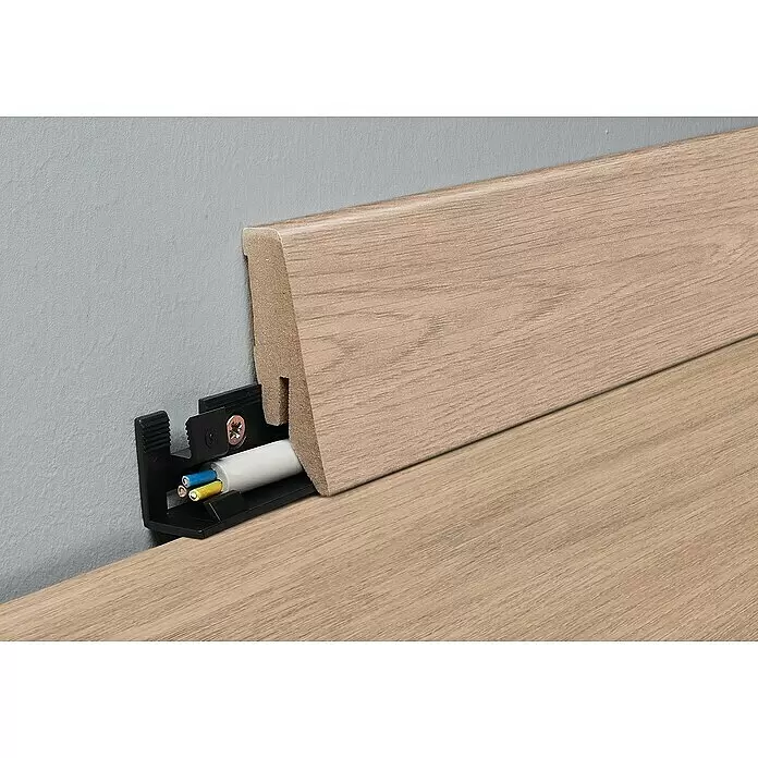 MyStyle Sockelleiste K58 C Spindrift Oak - 260 cm x 18 mm x 58 mm, MDF - Helle Holzleiste mit verstecktem Kabelkanal. Ein weißes Kabel mit farbigen Adern ist sichtbar.
