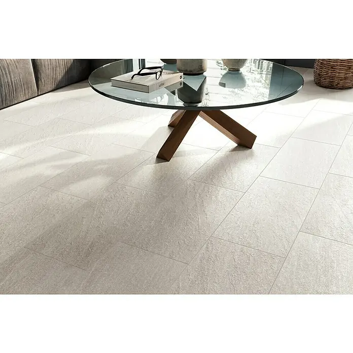 Atlas Concorde Solution Lane Feinsteinzeugfliese - 30 x 60 cm, Pearl, Matt - Diese Aufnahme zeigt die zeitlose Eleganz grauer Bodenfliesen, die einen neutralen Hintergrund für den eleganten Glastisch bilden.