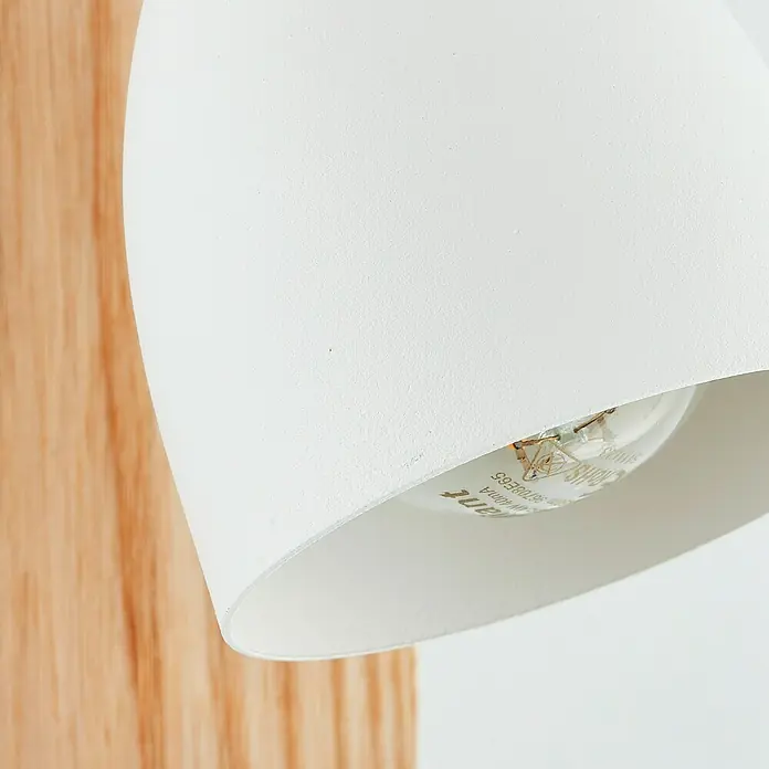 Brilliant Daintree Wandstrahler - 28 W, Weiß/Natur, E14, 1 Stk. - Nahaufnahme einer weißen Lampe mit einer Glühbirne, die an einer Holzwand befestigt ist. Elegantes und minimalistisches Design für moderne Innenräume.
