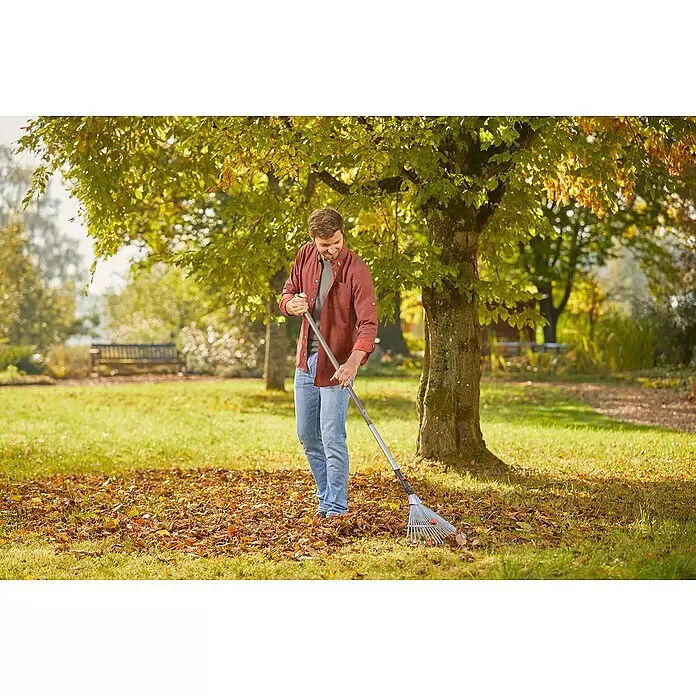 Gardena Combisystem Verstellbesen - Arbeitsbreite: 30 cm - 50 cm, Aluminium - Mann harkelt Herbstlaub mit einer grauen Gartenharke in einem sonnigen Garten.