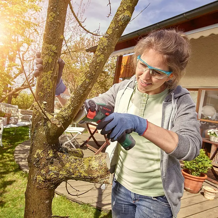 Bosch Power for All 12V NanoBlade-Säge EasyCut 12 - 12 V, 1 Akku, 2 Ah, Leerlaufdrehzahl: 4.100 U/min - Frau schneidet einen Baum mit einer Bosch Akku-Säbelsäge.