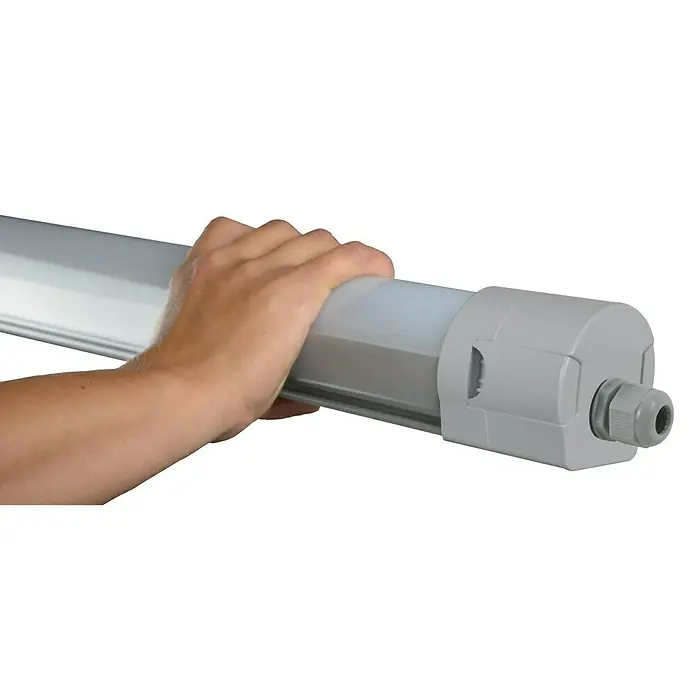 E2 elektro LED-Feuchtraumlichtleiste - L x B x H: 147 x 6 x 6 cm, Lichtfarbe: Neutralweiß, 50 W, IP65 - Eine Hand hält eine graue LED-Feuchtraumleuchte. Die Leuchte ist länglich und hat eine graue Endkappe mit Kabelverschraubung.