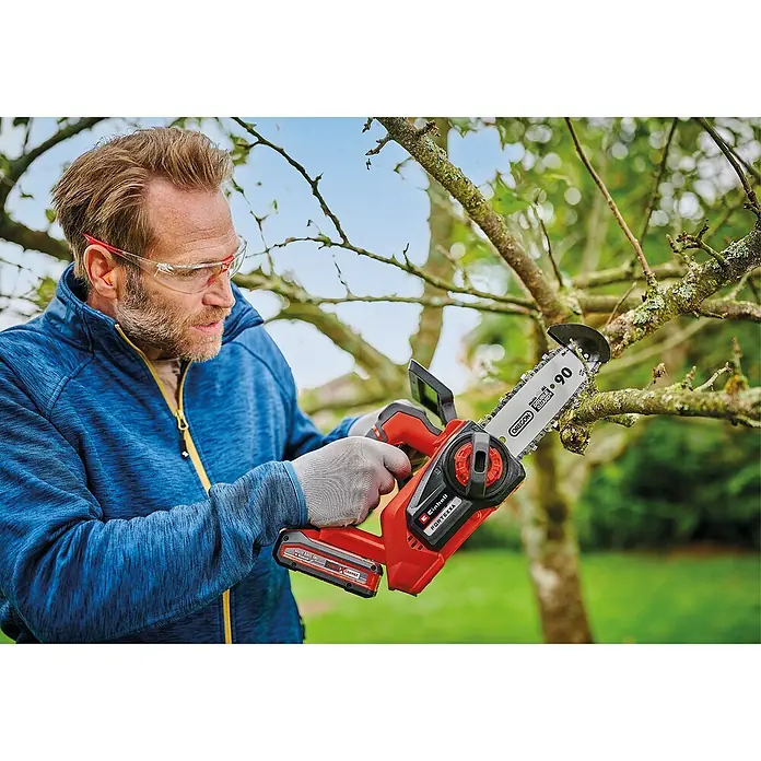 Einhell Motosierra de batería Fortexxa 18/20 TH - 18 V, 3 Ah, Iones de litio, 1 batería, Longitud de la cuchilla: 20 cm - Hombre podando una rama con una sierra de podar inalámbrica Einhell Fortexxa, asegurando cortes precisos.
