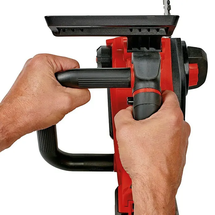 Einhell Motosierra de batería Fortexxa 18/20 TH - 18 V, 3 Ah, Iones de litio, 1 batería, Longitud de la cuchilla: 20 cm - Un primer plano de manos sosteniendo una motosierra de poda inalámbrica, diseñada para tareas de jardinería.