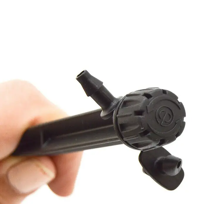 Gotero lineal regulable con estaca - Diámetro: 4 mm, 5 ud. - Primer plano de un gotero negro ajustable para sistemas de riego, sostenido en una mano.