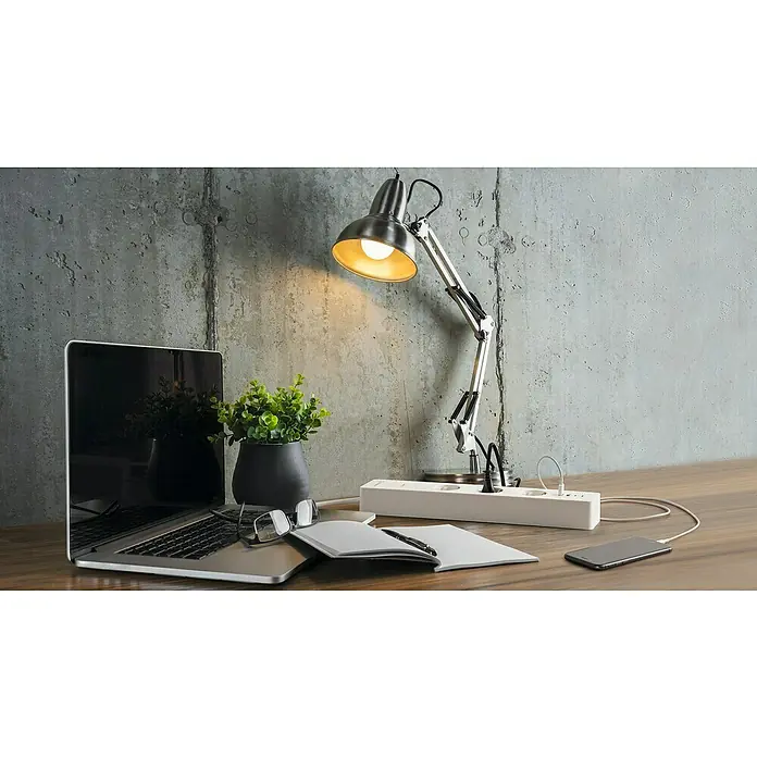 Osram Smart+ Smart-Steckdosenleiste (2. Gen.) - 3-fach, Weiß, Max. Anschlussleistung: 3.680 W, 4 x USB - Eine Schreibtischlampe beleuchtet einen Laptop, eine Pflanze und eine Steckdosenleiste auf einem Holztisch, ideal für einen modernen Arbeitsplatz.