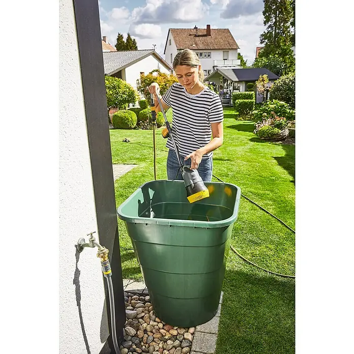 Neptun Regenfasspumpe NRP-E 40 - 400 W, Max. Fördermenge: 4.200 l/h - Eine Frau senkt eine graue und gelbe Pumpe in einen grünen Wasserbehälter im Garten, um Wasser abzupumpen.