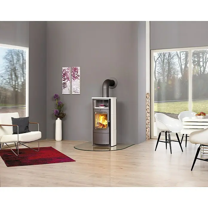 Hark Kaminofen Opera B - 5 kW, Raumheizvermögen: 138 m³, Material Verkleidung: Keramik, Creme/Weiß - Ein moderner Kaminofen in einem stilvollen Wohnzimmer, der Wärme und Eleganz ausstrahlt. Der Ofen ist ein echter Hingucker.