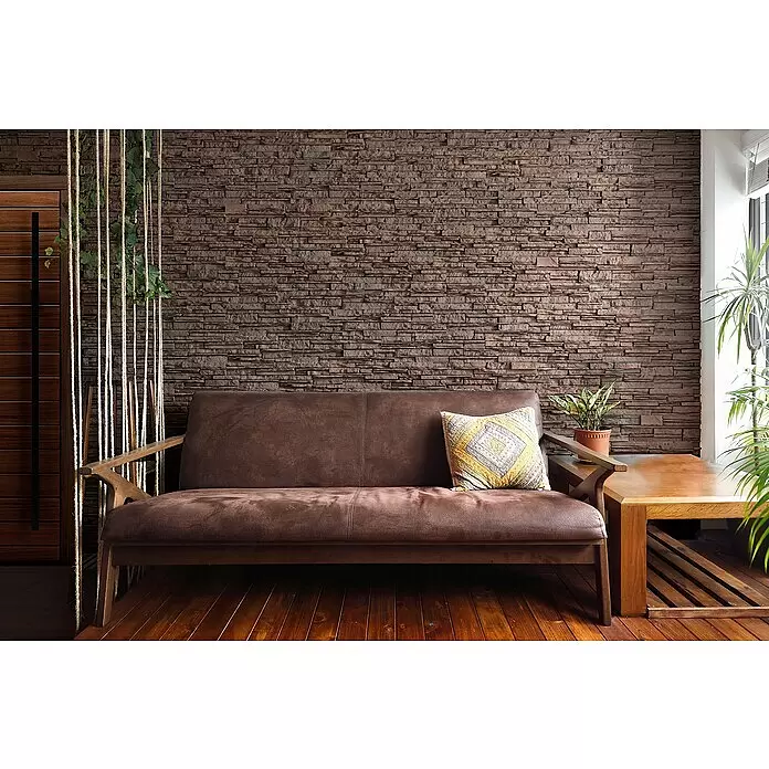 Stegu Verblendstein Kenya - 12 x 53,3 cm, Braun/Rot, Steinoptik - Ein braunes Sofa mit Holzrahmen und gemustertem Kissen in einem Wohnzimmer mit Steinwand und Holzboden.