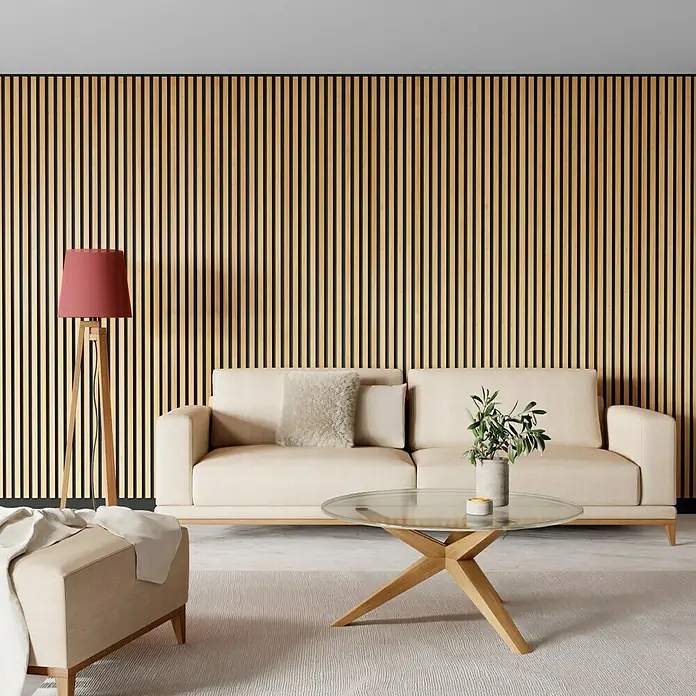 Panel acústico decorativo Premium Plus - 1,2 m x 0,6 m x 22 mm, Roble natural - Acogedor salón con sofá beige, mesa de centro de cristal y lámpara de pie roja contra una pared de listones de madera. Ambiente confortable.
