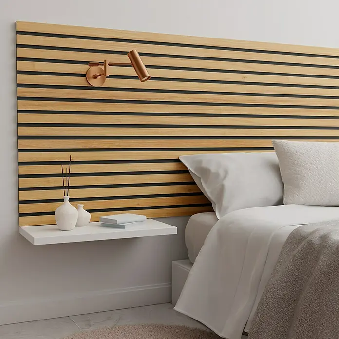 Panel acústico decorativo Premium Plus - 1,2 m x 0,6 m x 22 mm, Roble natural - Un dormitorio elegante con un cabecero de madera y una mesita de noche flotante que destaca el diseño moderno de la cama.