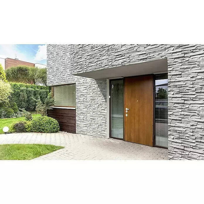 Stegu Verblendstein Denver - 20 x 34 cm, Grau, Steinoptik - Moderne Hausfassade mit grauer Natursteinverkleidung, einer Holzeingangstür und einem Fenster mit Jalousien, umgeben von Grün.