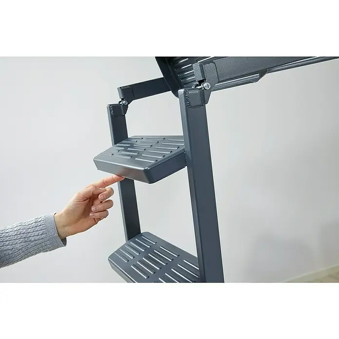 Sogem Escalera escamoteable Isoclic Pro Confort - 120 x 60 cm, Aislamiento térmico: 0,49 W/(m²K) - Primer plano de una persona inspeccionando una escalera plegable gris, enfatizando la funcionalidad y el diseño de la escalera.